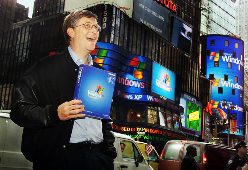 Bill Gates a segurar caixa do Windows XP em frente à Bolsa de Valores NASDAQ